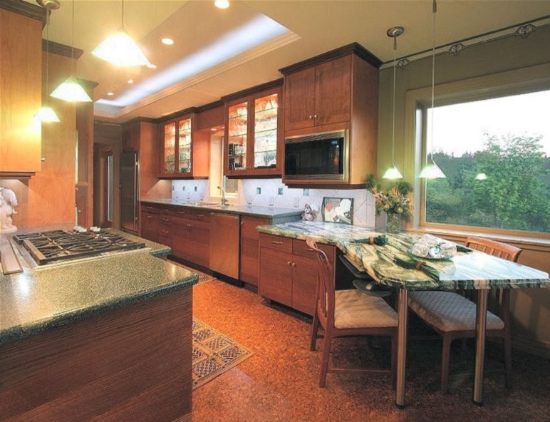 Foto på ett stort eklektiskt grön kök, med en undermonterad diskho, luckor med infälld panel, skåp i mellenmörkt trä, bänkskiva i kvartsit, beige stänkskydd, stänkskydd i porslinskakel, rostfria vitvaror, korkgolv och brunt golv
