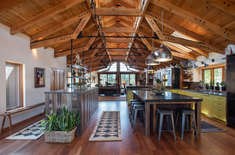 Photo of a rural l-shaped open plan kitchen in Denver with multiple islands, a submerged sink, shaker cabinets, green cabinets, medium hardwood flooring, brown floors, grey worktops, exposed beams, a vaulted ceiling and a wood ceiling.