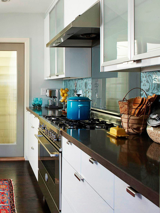 Foto på ett funkis kök, med en undermonterad diskho, luckor med glaspanel, vita skåp, bänkskiva i kvarts och rostfria vitvaror