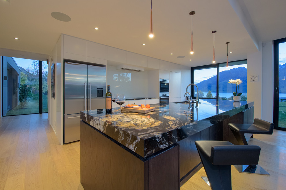 Immagine di una cucina minimalista con nessun'anta, parquet chiaro e pavimento marrone