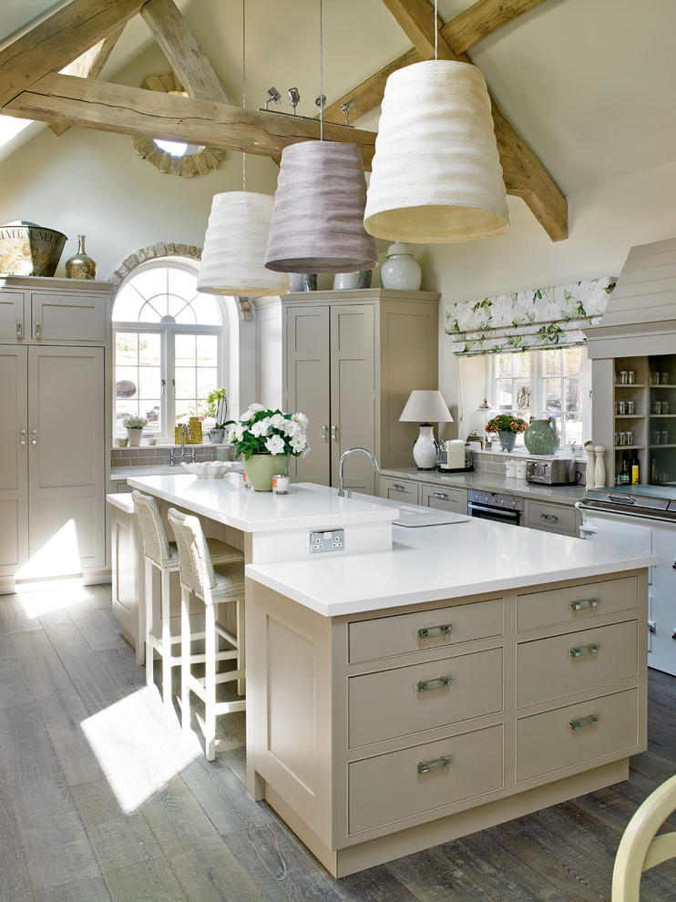Inspiration for a large french country u-shaped medium tone wood floor enclosed kitchen remodel in London with flat-panel cabinets, beige cabinets, stainless steel appliances and an island