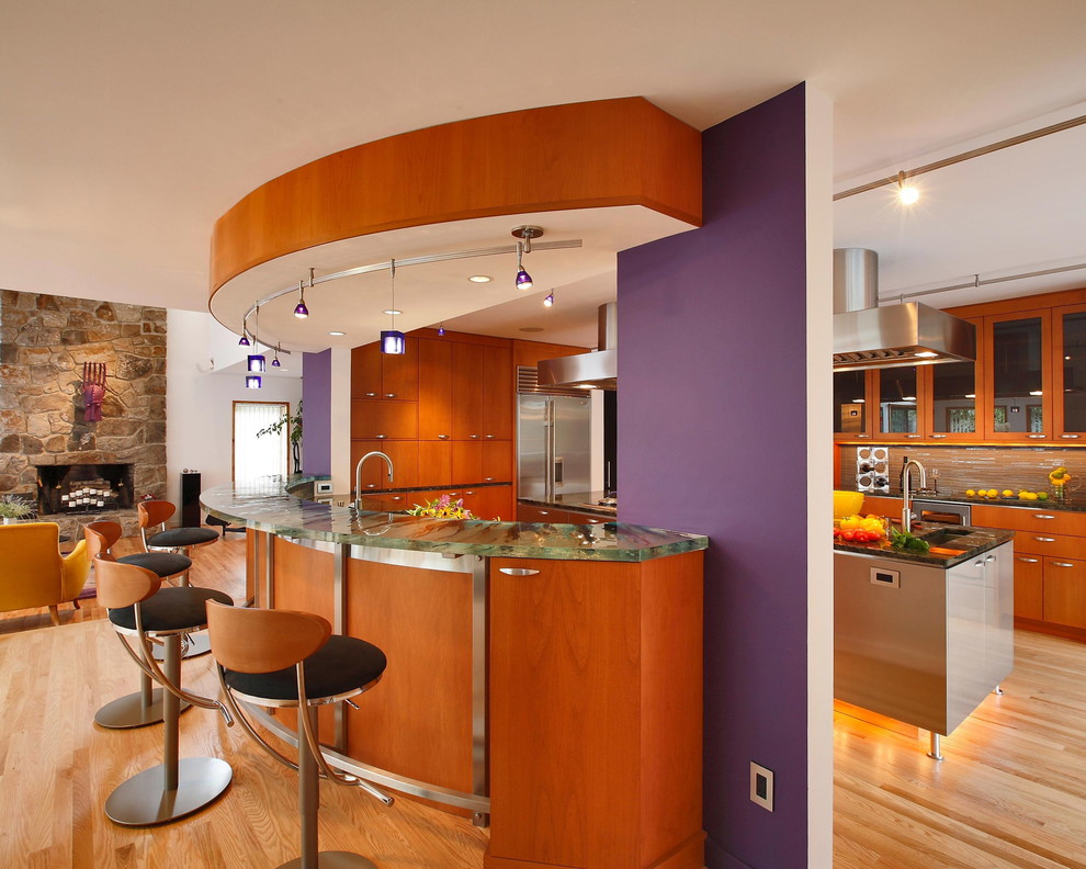 Moderne Küche mit flächenbündigen Schrankfronten, hellbraunen Holzschränken, Küchenrückwand in Braun, Küchengeräten aus Edelstahl und grüner Arbeitsplatte in New York