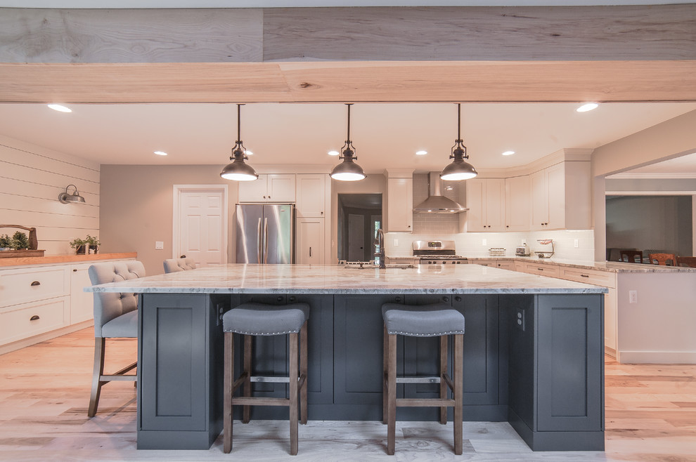 Inspiration for a large farmhouse u-shaped light wood floor and beige floor open concept kitchen remodel in Detroit with an undermount sink, shaker cabinets, white cabinets, granite countertops, white backsplash, stainless steel appliances and an island