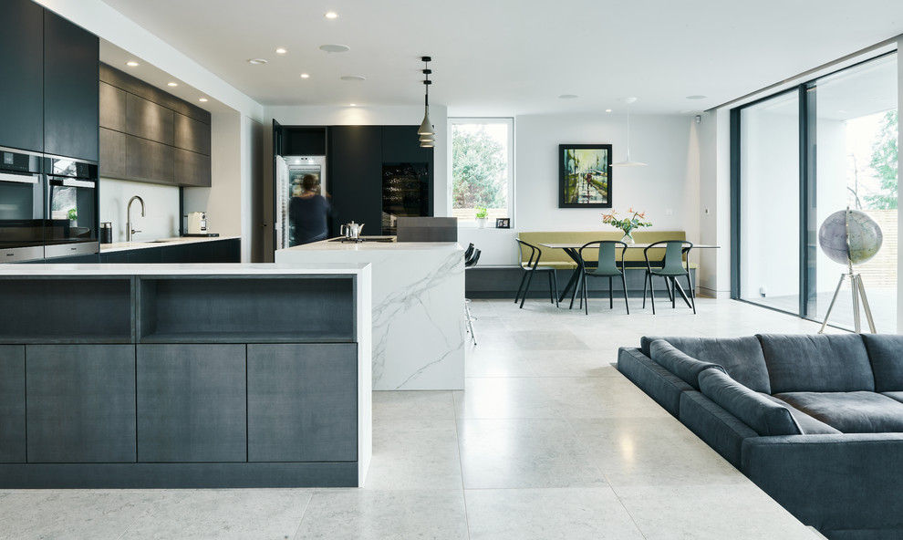 Photo of a contemporary open plan kitchen in Devon with a submerged sink, flat-panel cabinets, black cabinets, white splashback, integrated appliances, an island, white floors and white worktops.