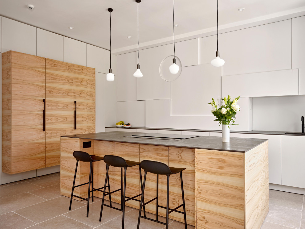 Idéer för ett mellanstort modernt grå kök, med en enkel diskho, släta luckor, skåp i ljust trä, bänkskiva i kvarts, vitt stänkskydd, glaspanel som stänkskydd, svarta vitvaror, kalkstensgolv, en köksö och beiget golv