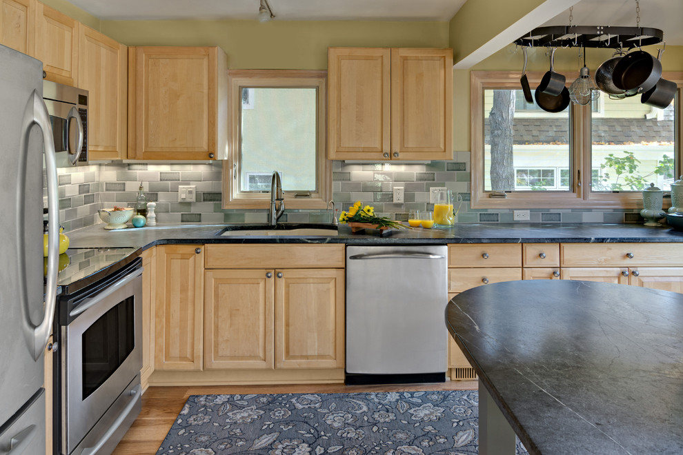 Example of a small eclectic l-shaped medium tone wood floor and brown floor enclosed kitchen design in Minneapolis with an undermount sink, raised-panel cabinets, light wood cabinets, soapstone countertops, blue backsplash, subway tile backsplash, stainless steel appliances, a peninsula and gray countertops