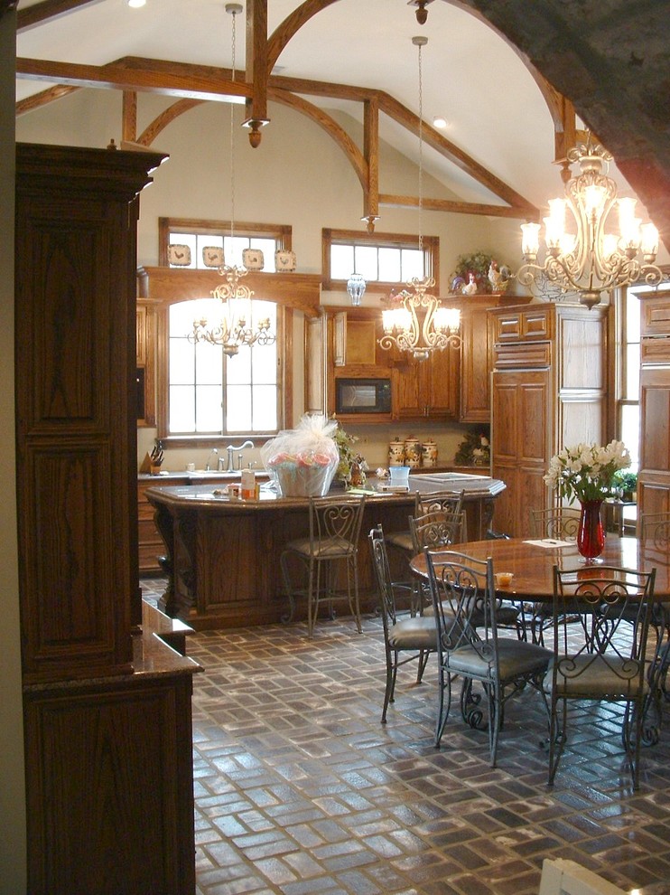 Esempio di una grande cucina vittoriana con lavello sottopiano, ante con bugna sagomata, ante in legno bruno, top in granito, elettrodomestici da incasso, pavimento in mattoni e pavimento marrone