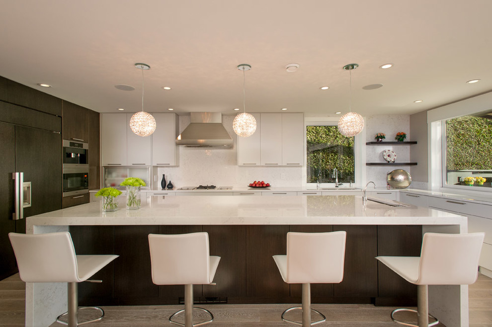 Inspiration for a contemporary u-shaped open plan kitchen in Vancouver with a submerged sink, flat-panel cabinets, engineered stone countertops, white splashback, integrated appliances and stone slab splashback.