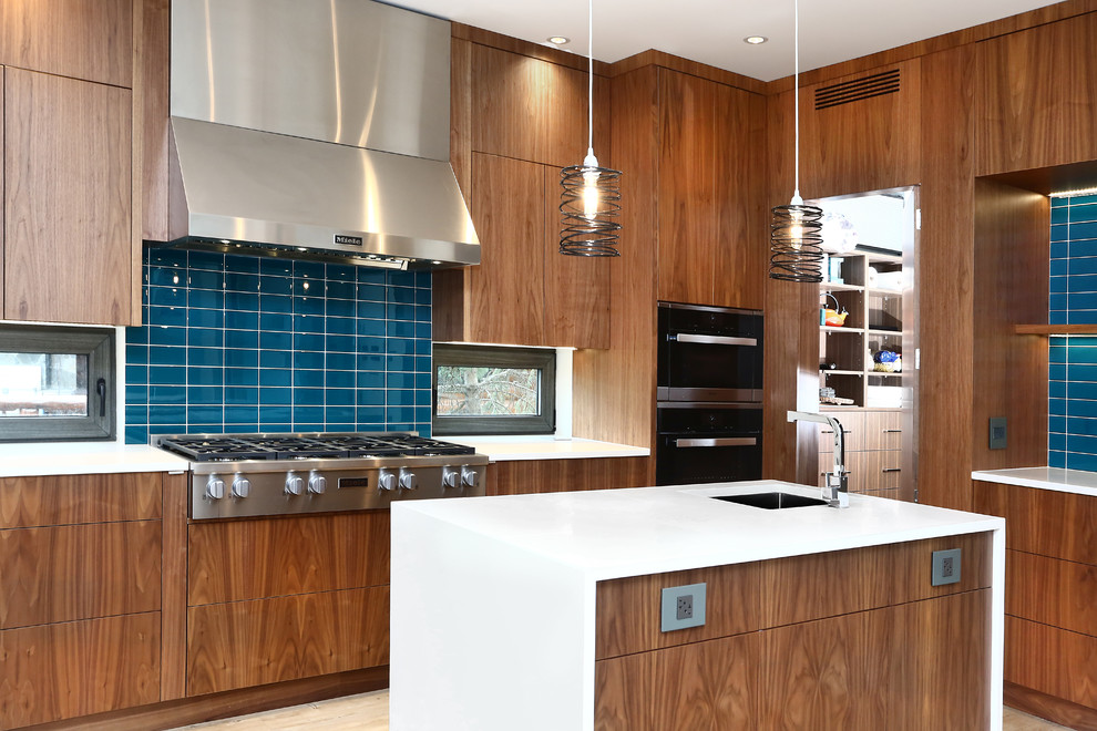 Huge l-shaped bamboo floor and gray floor eat-in kitchen photo in Vancouver with a drop-in sink, flat-panel cabinets, light wood cabinets, quartz countertops, blue backsplash, glass tile backsplash, stainless steel appliances and two islands