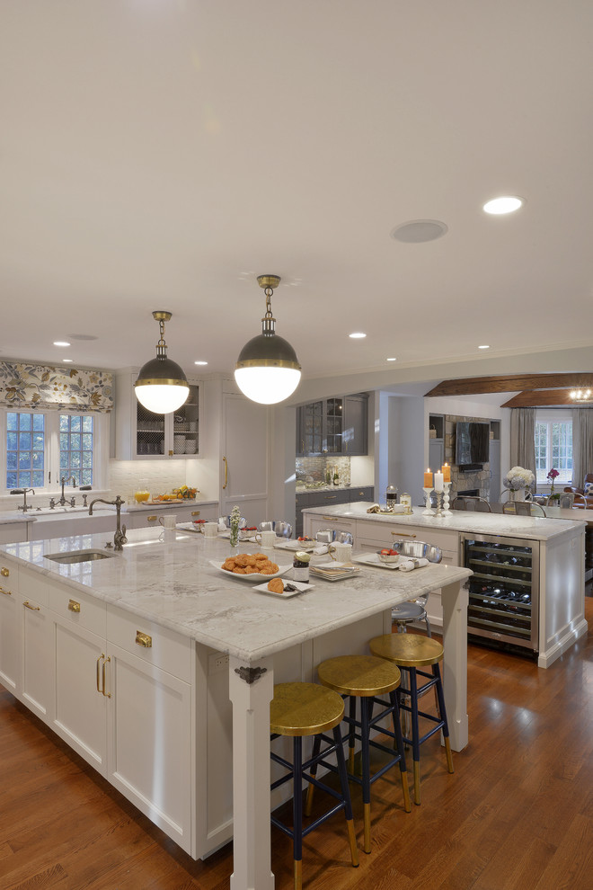 Huge transitional l-shaped dark wood floor eat-in kitchen photo in New York with a farmhouse sink, recessed-panel cabinets, white cabinets, quartzite countertops, white backsplash, ceramic backsplash, colored appliances and two islands