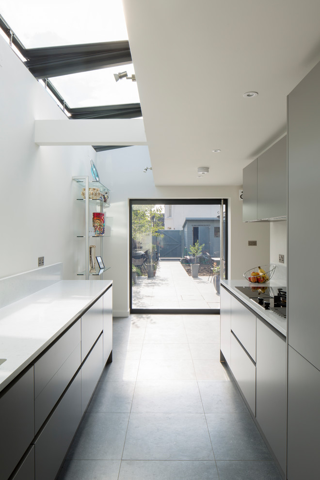 Cette photo montre une petite cuisine ouverte parallèle tendance avec un placard à porte plane, des portes de placard grises, un sol gris et un plan de travail gris.
