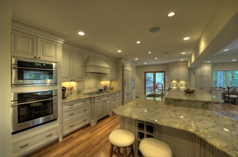 Exempel på ett mycket stort modernt kök, med luckor med infälld panel, vita skåp, vitt stänkskydd, rostfria vitvaror, ljust trägolv och en köksö