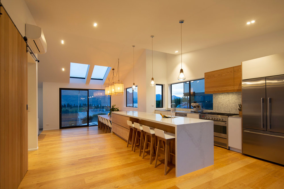 Cette image montre une grande cuisine ouverte parallèle minimaliste avec 2 îlots.