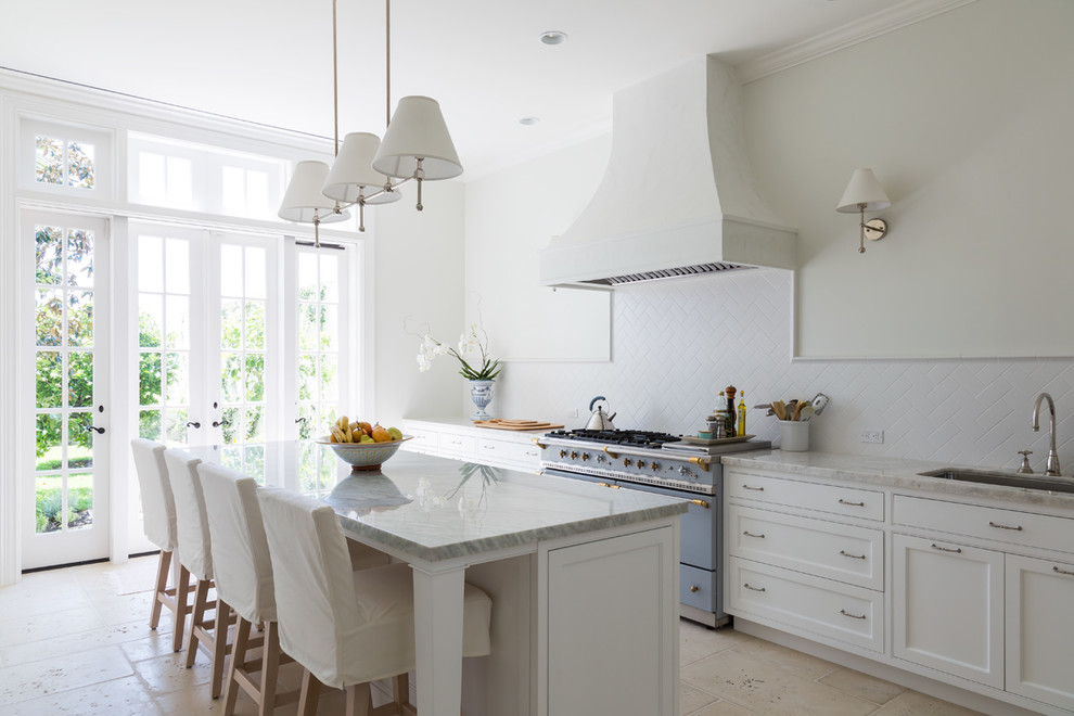 Design ideas for a large traditional single-wall kitchen/diner in Miami with a submerged sink, white cabinets, white splashback, coloured appliances, an island, recessed-panel cabinets, marble worktops, porcelain splashback, limestone flooring and beige floors.