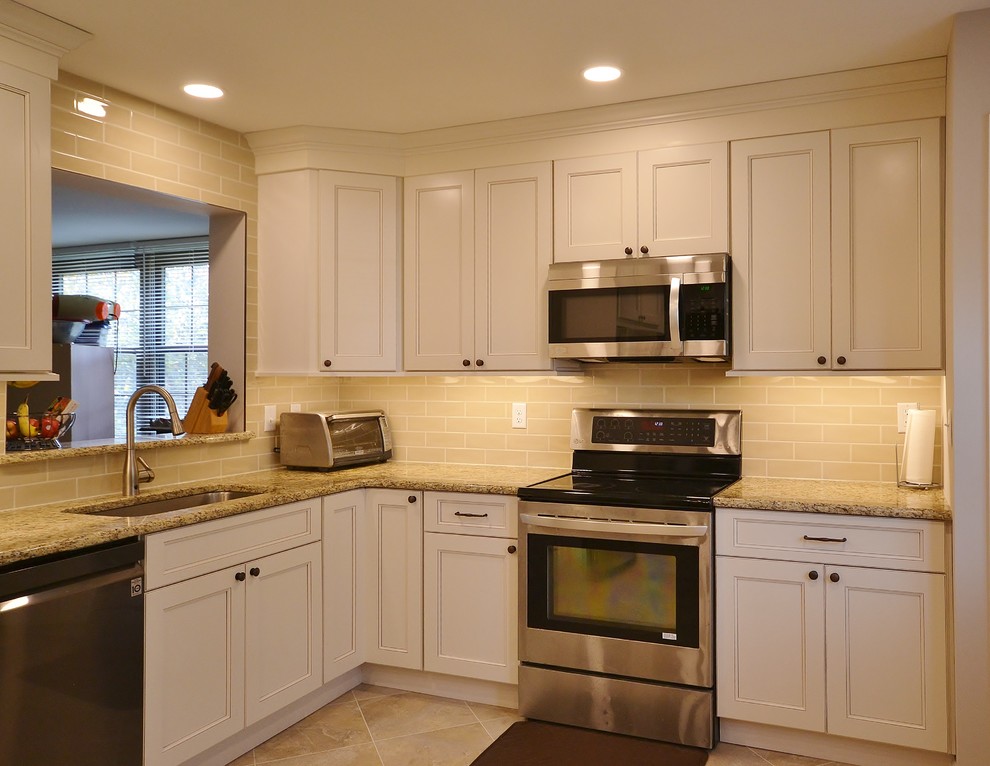 Exempel på ett mellanstort klassiskt beige beige kök, med en undermonterad diskho, luckor med infälld panel, gula skåp, granitbänkskiva, beige stänkskydd, stänkskydd i tunnelbanekakel, rostfria vitvaror, vinylgolv och beiget golv