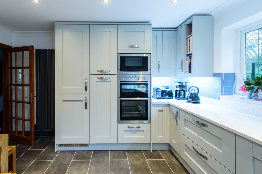 Immagine di una cucina design con ante in stile shaker, ante grigie, top in quarzite, paraspruzzi blu, paraspruzzi con piastrelle in ceramica e elettrodomestici in acciaio inossidabile