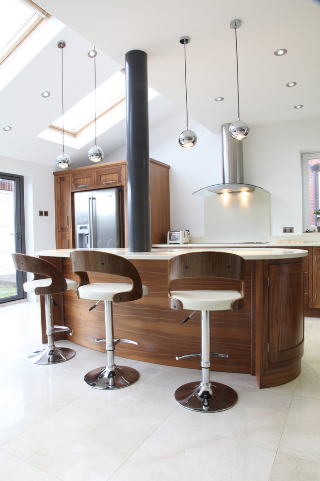 Immagine di una grande cucina contemporanea con ante in stile shaker, ante in legno bruno, paraspruzzi beige e elettrodomestici in acciaio inossidabile