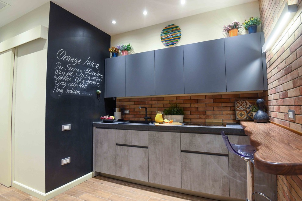 Design ideas for a small modern single-wall kitchen/diner in Other with a built-in sink, flat-panel cabinets, grey cabinets, laminate countertops, brown splashback, brick splashback, black appliances, cement flooring, no island, brown floors and grey worktops.