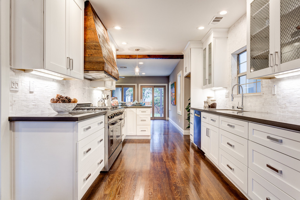 Example of a mid-sized minimalist galley dark wood floor open concept kitchen design in Sacramento with an undermount sink, shaker cabinets, white cabinets, quartz countertops, white backsplash, stone tile backsplash, stainless steel appliances and a peninsula