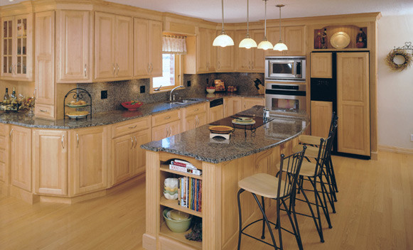Exempel på ett avskilt, stort modernt l-kök, med en dubbel diskho, luckor med upphöjd panel, skåp i ljust trä, granitbänkskiva, grått stänkskydd, stänkskydd i sten, integrerade vitvaror, ljust trägolv, en köksö och beiget golv