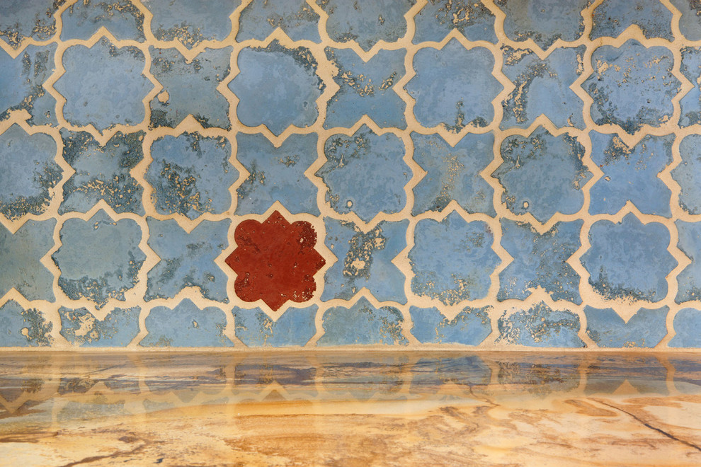 На фото: угловая кухня-гостиная среднего размера в средиземноморском стиле с накладной мойкой, фасадами с выступающей филенкой, синими фасадами, мраморной столешницей, синим фартуком, фартуком из цементной плитки, техникой из нержавеющей стали, мраморным полом, островом и коричневым полом с