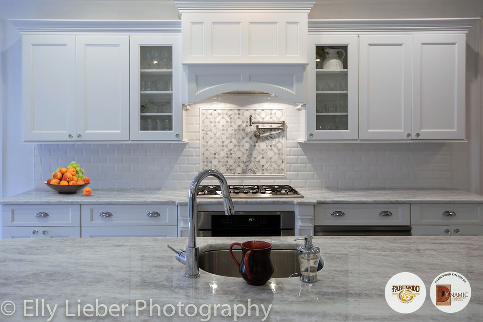 Immagine di una grande cucina chic con lavello a vasca singola, ante con bugna sagomata, ante in legno chiaro e elettrodomestici in acciaio inossidabile