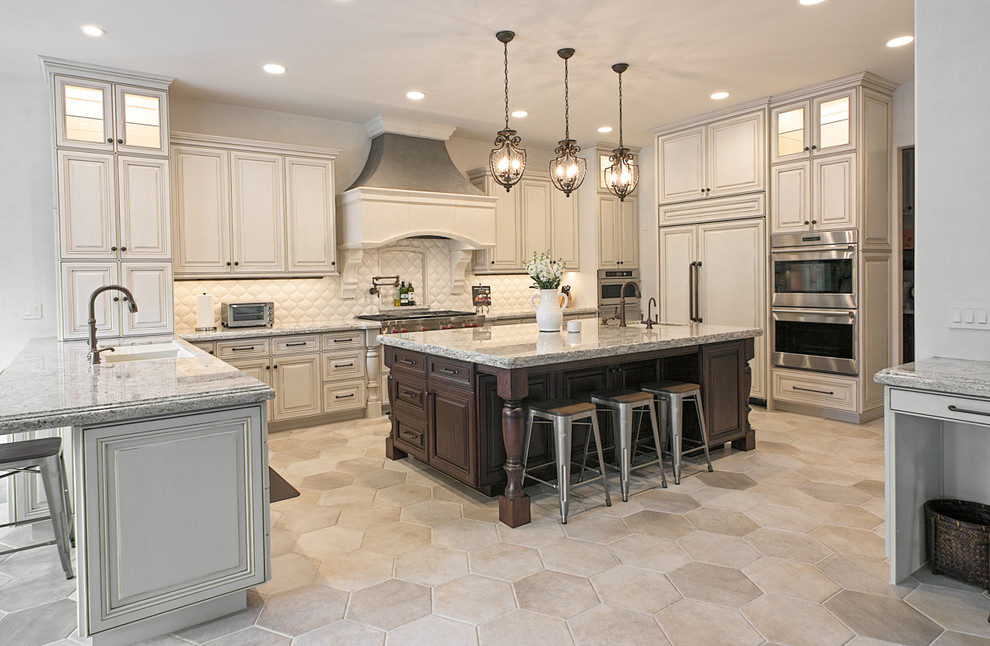 Foto på ett stort medelhavsstil kök, med en undermonterad diskho, luckor med upphöjd panel, vita skåp, granitbänkskiva, vitt stänkskydd, stänkskydd i porslinskakel, rostfria vitvaror, klinkergolv i keramik och en köksö