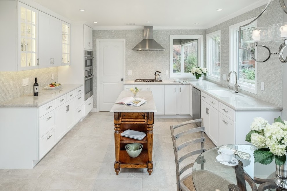Large transitional u-shaped limestone floor and gray floor eat-in kitchen photo in Sacramento with an undermount sink, shaker cabinets, white cabinets, marble countertops, metallic backsplash, mosaic tile backsplash, stainless steel appliances and an island