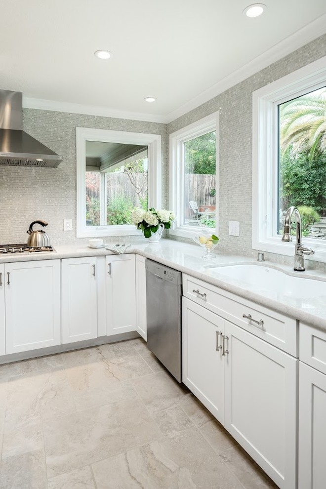 Example of a large transitional u-shaped limestone floor eat-in kitchen design in Sacramento with an undermount sink, shaker cabinets, white cabinets, marble countertops, metallic backsplash, mosaic tile backsplash, stainless steel appliances and an island