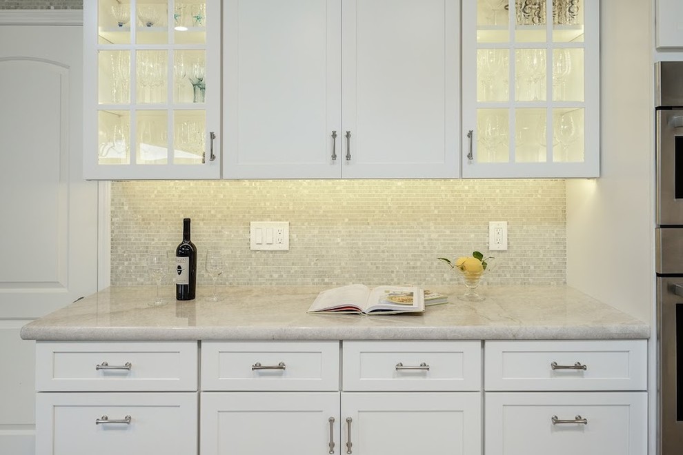Large transitional u-shaped limestone floor eat-in kitchen photo in Sacramento with an undermount sink, shaker cabinets, white cabinets, marble countertops, metallic backsplash, mosaic tile backsplash, stainless steel appliances and an island