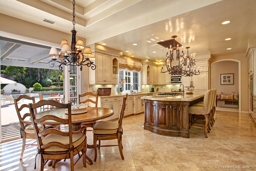 Tuscan u-shaped eat-in kitchen photo in San Diego with an undermount sink, raised-panel cabinets, beige cabinets, granite countertops, beige backsplash, stone tile backsplash and stainless steel appliances