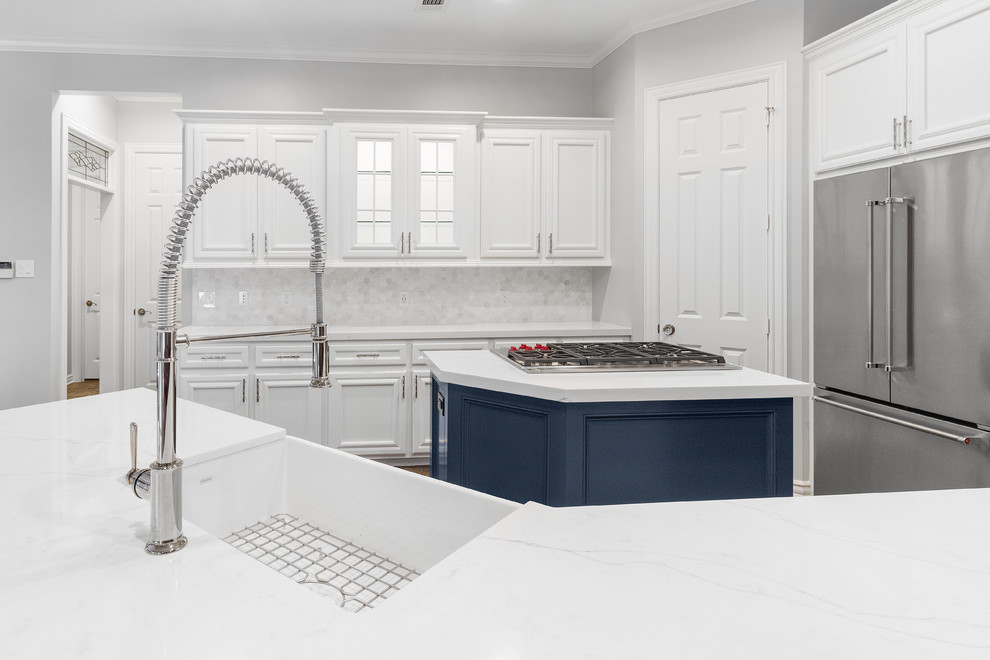 Medium sized classic u-shaped kitchen/diner in Houston with a belfast sink, recessed-panel cabinets, white cabinets, engineered stone countertops, white splashback, limestone splashback, stainless steel appliances, slate flooring, an island, brown floors and white worktops.
