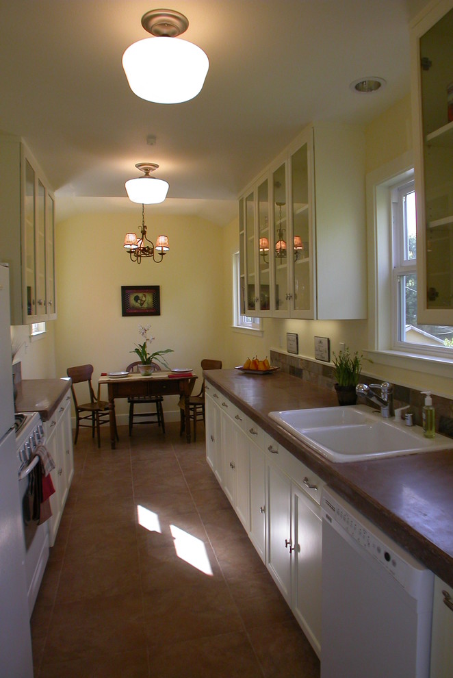 Example of a small country galley porcelain tile and brown floor kitchen design in San Francisco with a double-bowl sink, shaker cabinets, white cabinets, concrete countertops, brown backsplash, slate backsplash, white appliances and no island