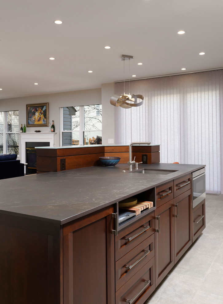 Example of a large trendy single-wall porcelain tile and gray floor open concept kitchen design in DC Metro with a single-bowl sink, flat-panel cabinets, brown cabinets, quartz countertops, blue backsplash, ceramic backsplash, stainless steel appliances, an island and black countertops