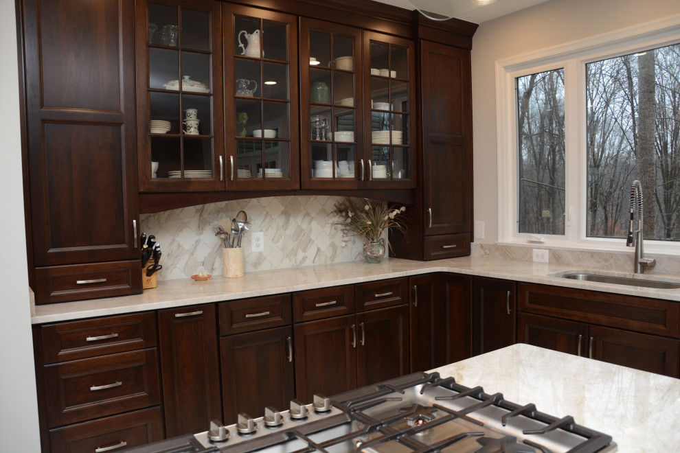 Exempel på ett stort klassiskt beige beige kök, med en undermonterad diskho, luckor med infälld panel, skåp i mörkt trä, bänkskiva i kvartsit, beige stänkskydd, rostfria vitvaror, en köksö och beiget golv