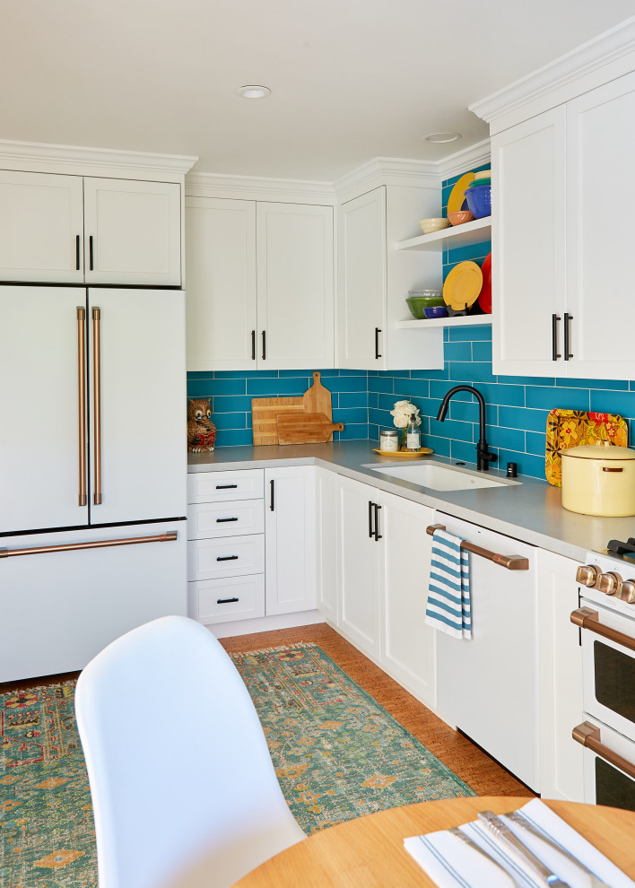 Eat-in kitchen - mid-sized coastal l-shaped medium tone wood floor and brown floor eat-in kitchen idea in San Francisco with an undermount sink, shaker cabinets, white cabinets, blue backsplash, white appliances, gray countertops, quartz countertops, subway tile backsplash and no island