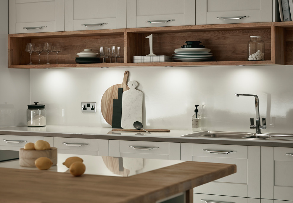 Immagine di una cucina lineare minimal con lavello integrato, ante in stile shaker, ante grigie, paraspruzzi bianco e elettrodomestici da incasso