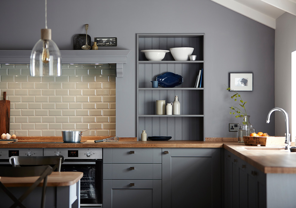 Photo of a medium sized farmhouse kitchen in Other with an integrated sink, shaker cabinets, grey cabinets, white splashback, metro tiled splashback and integrated appliances.