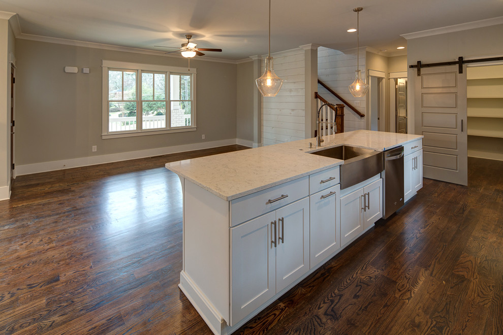Design ideas for a large classic l-shaped kitchen/diner in Atlanta with a belfast sink, recessed-panel cabinets, white cabinets, engineered stone countertops, brown splashback, metro tiled splashback, stainless steel appliances, dark hardwood flooring and an island.