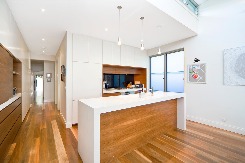 Moderne Küche mit flächenbündigen Schrankfronten, weißen Schränken und Elektrogeräten mit Frontblende in Sydney