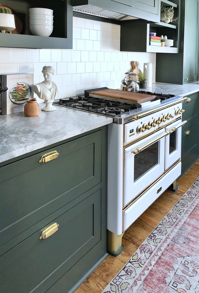 Imagen de cocinas en L tradicional renovada pequeña cerrada con armarios estilo shaker, puertas de armario verdes, salpicadero blanco y suelo de madera oscura