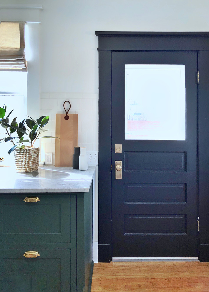 Example of a small transitional l-shaped dark wood floor enclosed kitchen design in Dallas with shaker cabinets, green cabinets and white backsplash