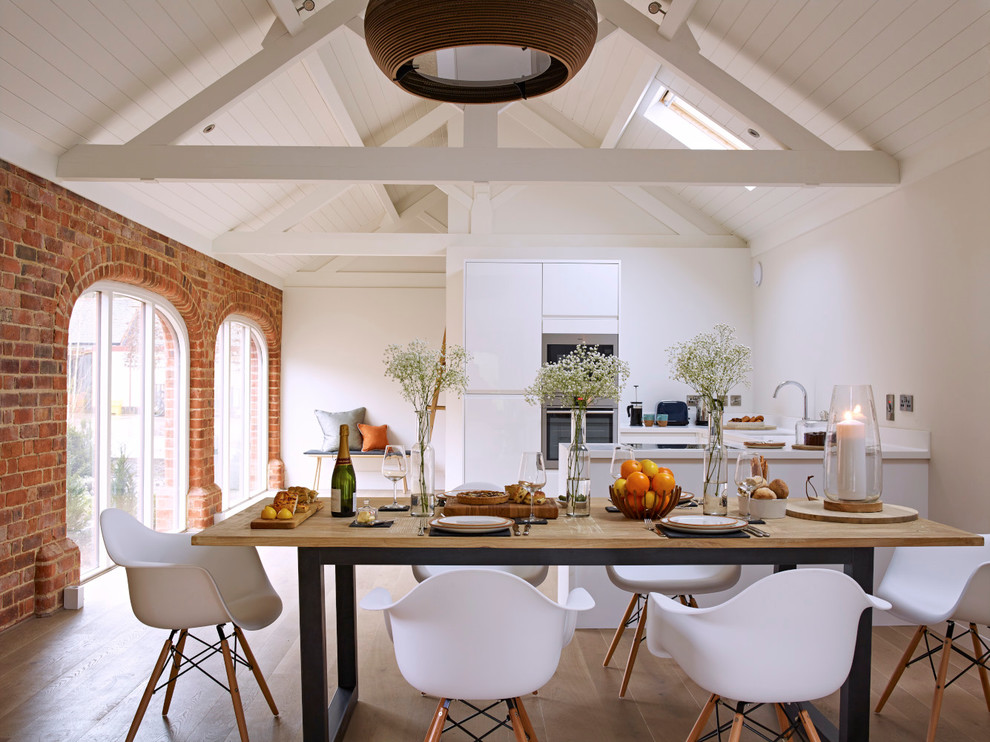 Landhausstil Küche in U-Form mit flächenbündigen Schrankfronten, weißen Schränken, Küchengeräten aus Edelstahl und braunem Holzboden in Gloucestershire