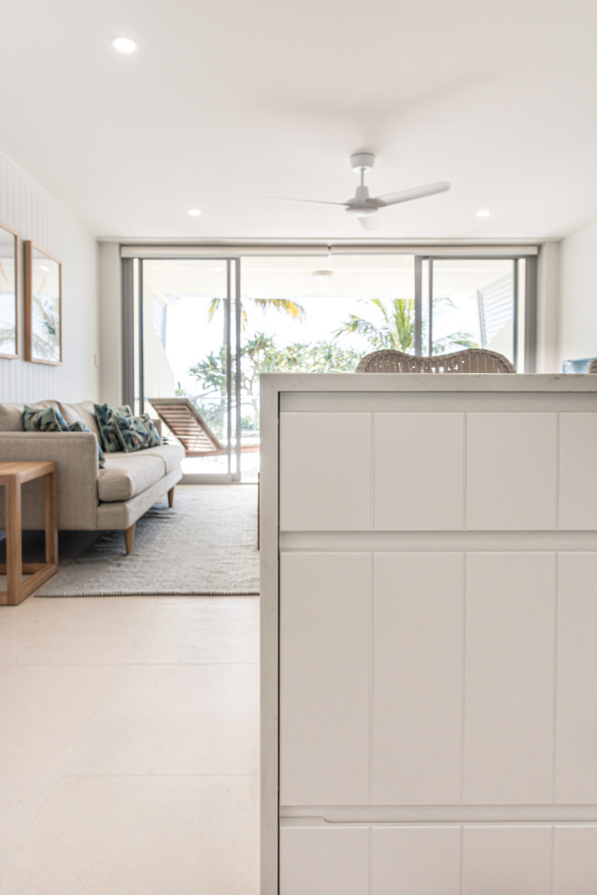 Example of a small beach style l-shaped porcelain tile and beige floor open concept kitchen design in Sunshine Coast with quartz countertops, white backsplash, quartz backsplash, stainless steel appliances, an island and white countertops