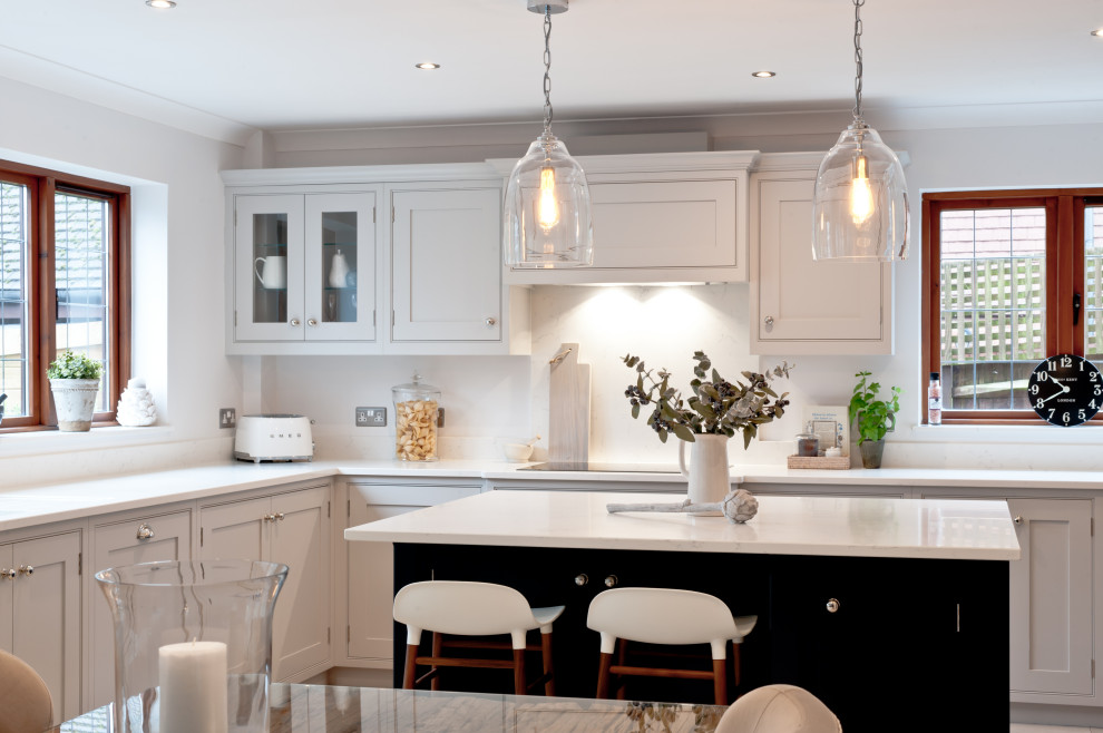 Design ideas for a medium sized traditional l-shaped kitchen/diner in Kent with shaker cabinets, grey cabinets, quartz worktops, white splashback, stainless steel appliances, an island and white worktops.
