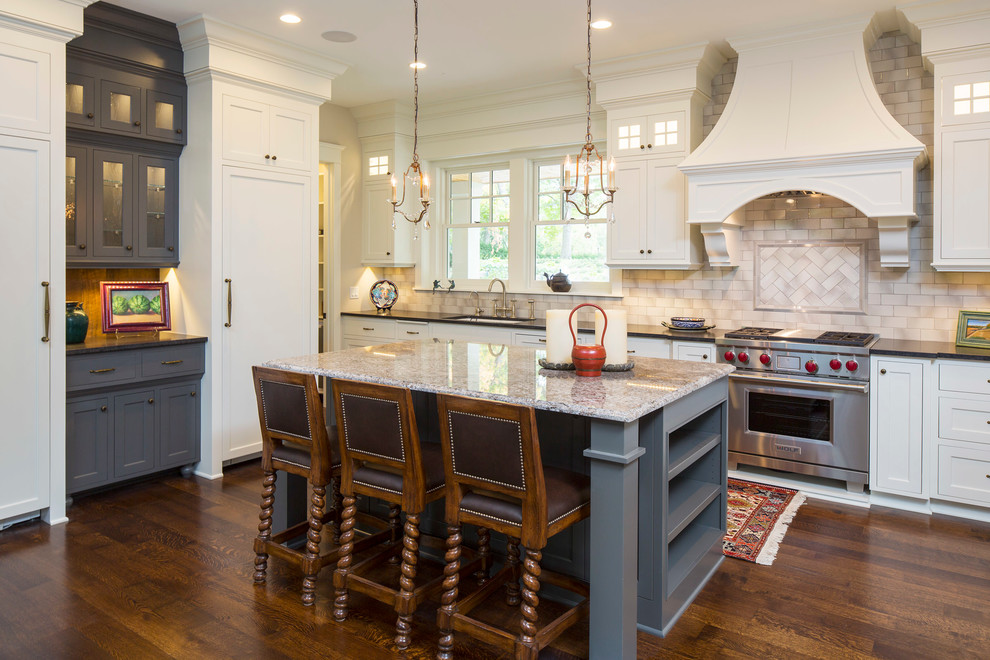 Traditional kitchen in Minneapolis with a submerged sink, shaker cabinets, white cabinets, beige splashback, integrated appliances, dark hardwood flooring and an island.