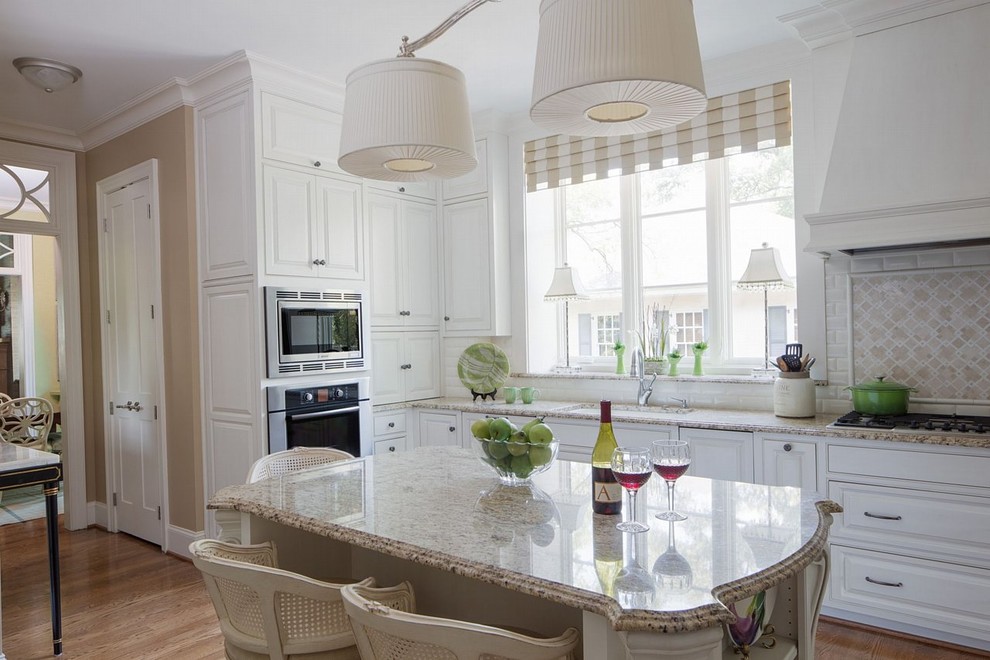 Photo of a large classic kitchen in Raleigh with a submerged sink, white cabinets, granite worktops, ceramic splashback, stainless steel appliances, medium hardwood flooring, an island, raised-panel cabinets, multi-coloured splashback and beige worktops.
