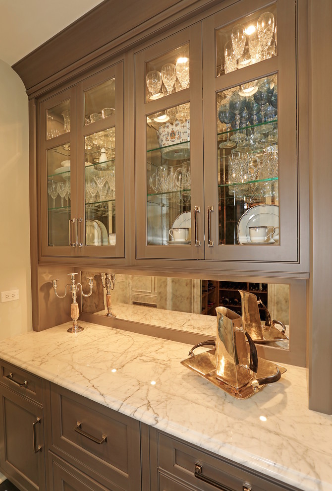 На фото: прямая кухня в классическом стиле с фасадами с утопленной филенкой, коричневыми фасадами и зеркальным фартуком