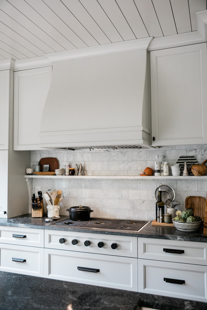 Foto på ett mellanstort funkis svart linjärt kök och matrum, med en undermonterad diskho, luckor med profilerade fronter, grå skåp, granitbänkskiva, vitt stänkskydd, stänkskydd i marmor, rostfria vitvaror, mellanmörkt trägolv, en köksö och brunt golv