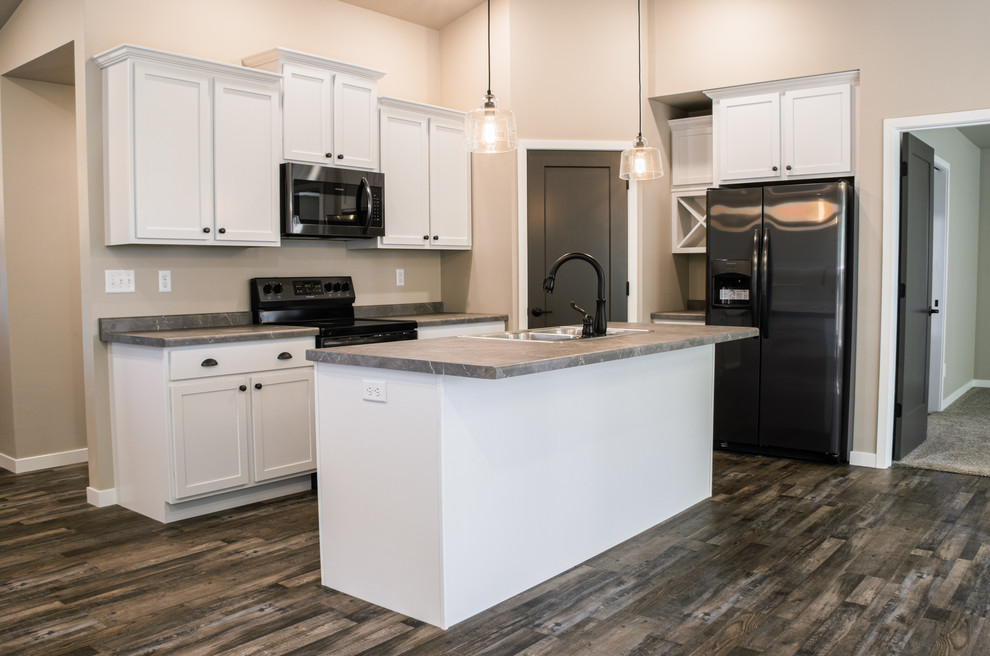 Medium sized industrial l-shaped open plan kitchen in Other with a built-in sink, shaker cabinets, white cabinets, laminate countertops, stainless steel appliances, medium hardwood flooring, an island, grey floors and multicoloured worktops.